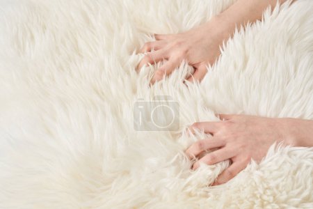 La main d'une femme touche le tissu duveteux