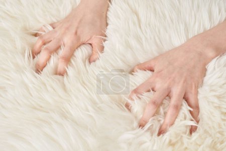A woman's hand touches the fluffy fabric