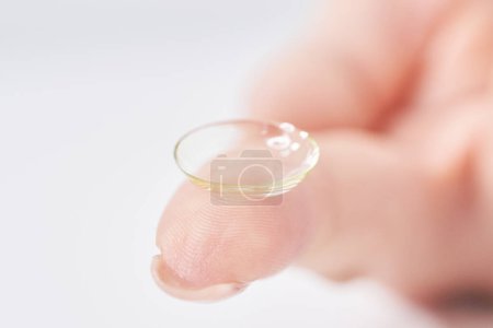Photo for Woman's fingers with contact lenses and white background - Royalty Free Image
