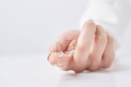 Finger der Frau mit Kontaktlinsen und weißem Hintergrund