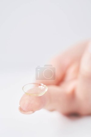 Foto de Dedos de mujer con lentes de contacto y fondo blanco - Imagen libre de derechos