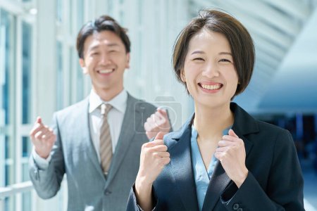 Man and woman in suits cheering with smile