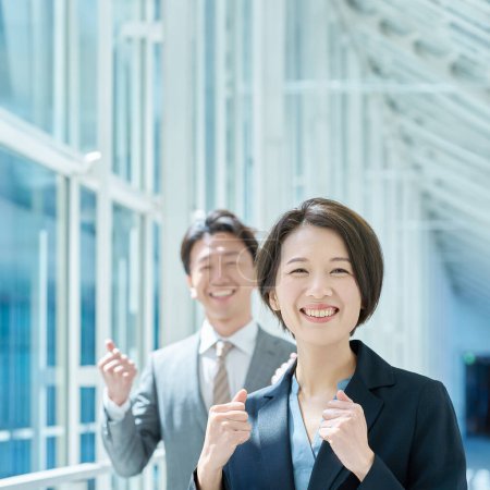 Man and woman in suits cheering with smile