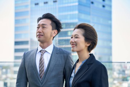Man and woman in suits and modern architecture on fine day