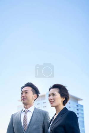 Téléchargez les photos : Homme et femme en costumes et architecture moderne au beau jour - en image libre de droit