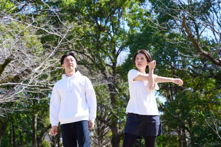 Foto de Hombre y mujer haciendo ejercicios de calentamiento en buen día - Imagen libre de derechos