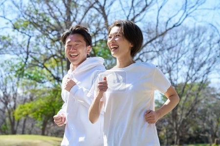 Man and woman running side by side on fine day