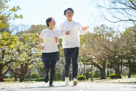 Man and woman running side by side on fine day