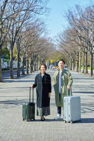 Foto de Un hombre y una mujer con maletas sonriendo - Imagen libre de derechos
