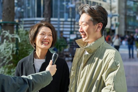 Männer und Frauen mittleren Alters werden auf der Straße interviewt