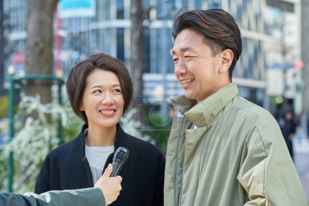 Middle-aged men and women being interviewed on the street