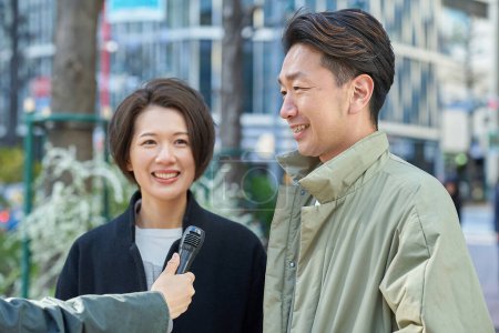 Middle-aged men and women being interviewed on the street