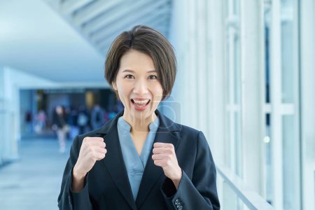 Business woman smiling and doing a fist pump