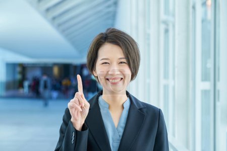 A business woman smiling and raising her index finger