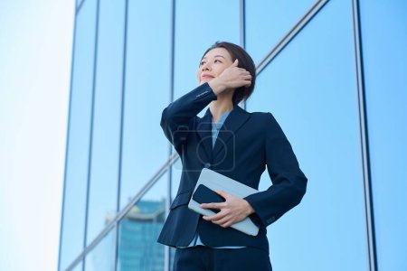 Business woman in a suit looking up at the sky outdoors