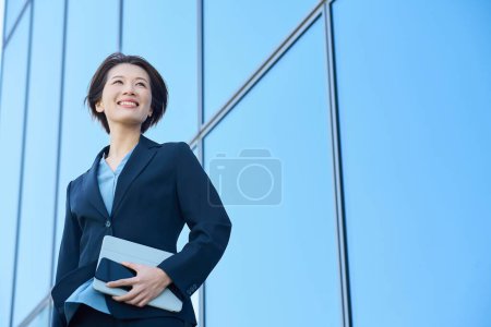 Téléchargez les photos : Femme d'affaires en costume regardant le ciel à l'extérieur - en image libre de droit