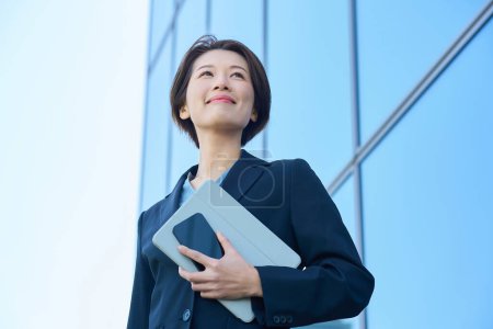 Business woman in a suit looking up at the sky outdoors