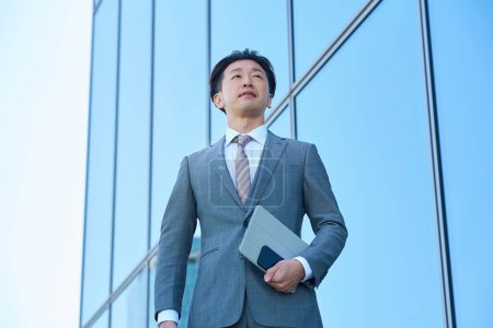 Businessman in a suit looking up at the sky outdoors