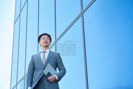 Foto de Empresario con traje mirando al cielo al aire libre - Imagen libre de derechos