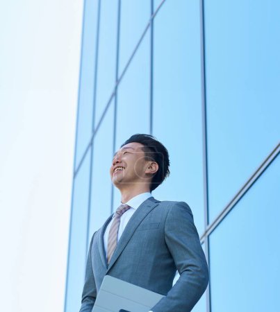 Businessman in a suit looking up at the sky outdoors