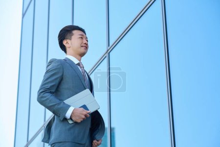 Empresario con traje mirando al cielo al aire libre