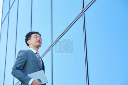 Empresario con traje mirando al cielo al aire libre