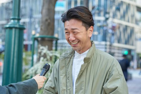 Middle-aged man being interviewed on the street