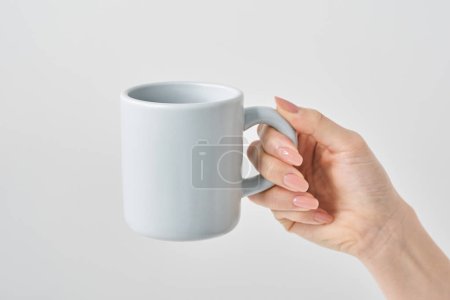 Woman's hand holding a mug and white background