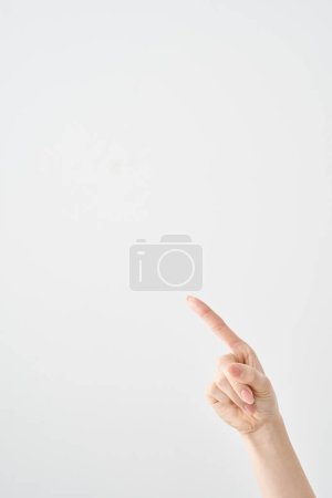 Der Zeigefinger einer Frau zeigt diagonal nach oben und weißer Hintergrund