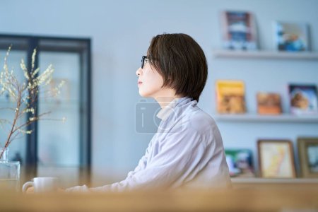 A middle-aged woman thinking in her room