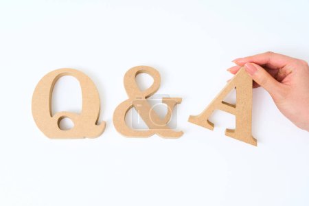 Blocs d'alphabet en bois disposés avec le mot "Q & A" et fond blanc
