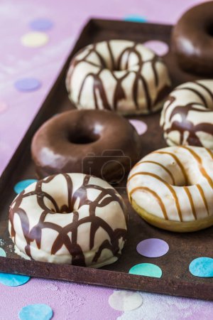 Téléchargez les photos : Chocolate Donuts, Berliner, Krapfen on a rusty tray on pink background - en image libre de droit