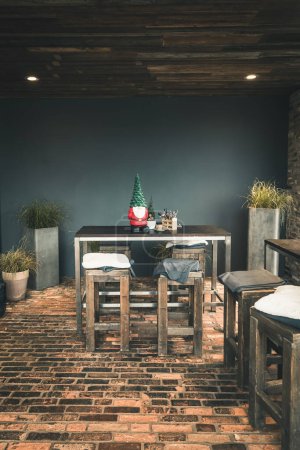 Photo for Outside of a cafe with wooden table and barstools and christmas decoration, vertical with copy space - Royalty Free Image