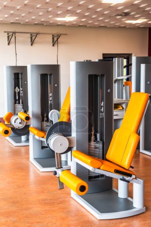 Máquina de fitness para entrenamiento de fuerza para piernas en sala de pesas, concepto de musculación, vertical