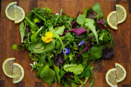 Salatherz mit Blütensalat auf Holzgrund