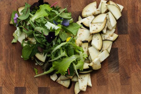 Salatherz mit Salat und Auberginen auf Holzgrund