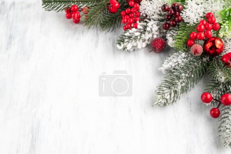 Téléchargez les photos : Image floue de branches de sapin et décor de Noël dans des tons rouges sur un fond en bois clair.Fond de Noël avec espace pour écrire du texte. - en image libre de droit
