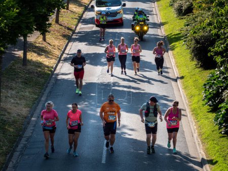 Photo for Caen, France Normandy June 4, 2023 happy women in pink t-shirts running Half Liberte Marathon in a group of Caen athletes, top view - Royalty Free Image