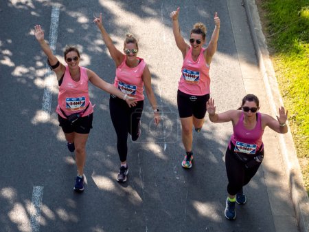 Foto de Caen, Francia Normandía 4 de junio de 2023 Happy women in pink t-shirts running Half Liberte Marathon in a group of Caen athletes, top view - Imagen libre de derechos
