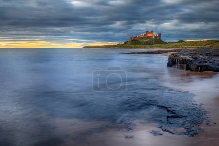 Foto de Castillo de Bamburgh amanecer en la costa de Northumberland - Imagen libre de derechos
