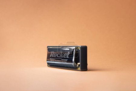 Téléchargez les photos : Harmonica diatonique professionnel Hohner Rocket se tient latéralement sur un fond brun clair, - en image libre de droit