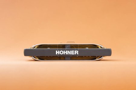 Téléchargez les photos : Hohner Rocket harmonica diatonique professionnel avec sa partie inférieure dans le cadre. Sur un fond brun clair - en image libre de droit
