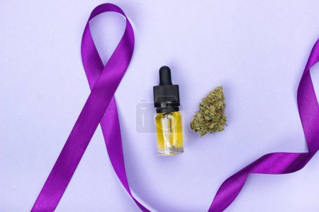Photo for Glass bottle with cbd oil extract.  Nearby is a dry bud of medical marijuana.  Epilepsy day symbol from the purple ribbon on the left.  On a purple background.  Alternative treatments for epilepsy - Royalty Free Image
