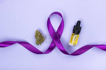 Foto de El símbolo del día de la epilepsia de una cinta púrpura, alrededor de los bordes de la misma es un brote seco de marihuana medicinal y una botella de vidrio con extracto de aceite de cbd amarillo. Sobre un fondo púrpura - Imagen libre de derechos