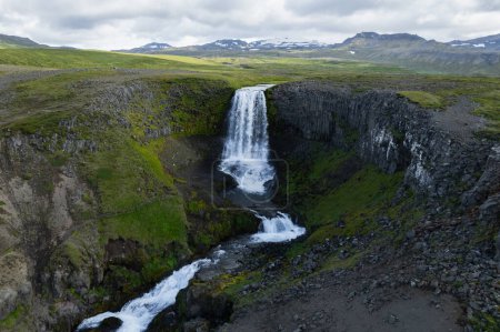 Drone Aerial of Kerlingarfoss Waterfall near Olafsvik on Icelands Snafellsnes peninsula. High quality photo. Beautiful waterfall with the Snaefellsjokull Volcano in the background.