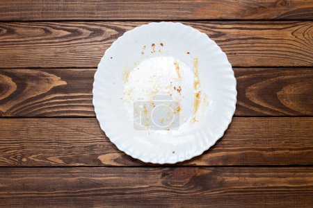 Téléchargez les photos : Assiette sale sur la table. les restes du déjeuner. vaisselle grasse, non lavée - en image libre de droit
