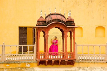 Téléchargez les photos : Femme à côté du Hawa Mahal, également connu sous le nom de Palais du Vent, dans la ville rose de Jaipur au Rajasthan, en Inde. - en image libre de droit