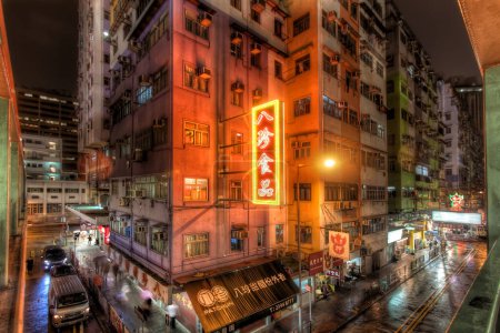 Photo for Hong Kong - 07 September 2016 - Night View of Rainy Dystopian Street with Red Neon Lights and Concrete Skyscrapers in Mong Kok, Hong Kong - Royalty Free Image
