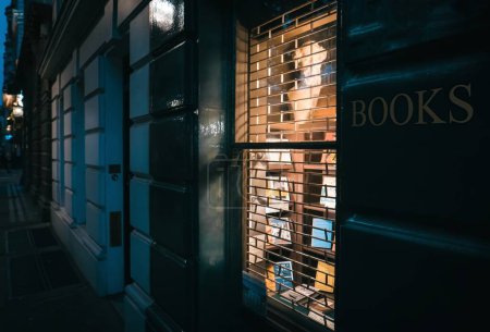 Tienda de libros cerrada de Londres por la noche con luz de la tienda caliente, Londres, Reino Unido