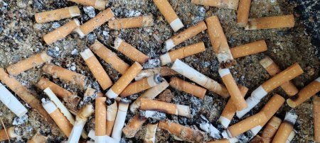 Foto de Cigarette butts combined in a cigarette disc Concept of many cigarette debris after smoking - Imagen libre de derechos